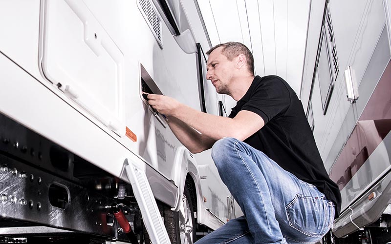 Mechaniker prüft Dichtigkeit an einem Wohnmobil